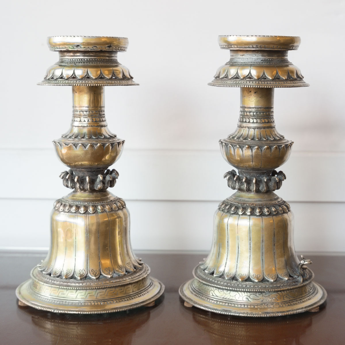 Paire de bougeoirs tibétains anciens en laiton repoussé